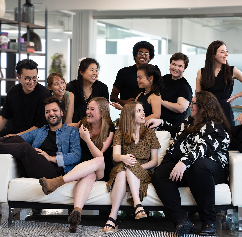 photo of Design B&B employees on a white couch smiling